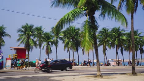 Zeitlupenperspektive-Des-Verkehrs-Auf-Der-Küstenstraße-Vor-Palmen-Und-Dem-Strand-Von-Ipanema-In-Rio