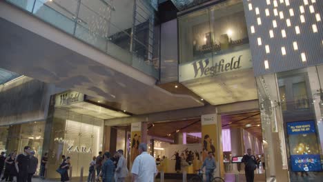 Bright-lights-and-retail-outlet-signs-with-busy-shoppers-in-Sydney-CBD