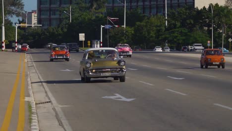 Handheld-tracking-shot-of-vintage-cars-in-Havana,-Cuba