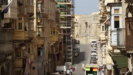 Balkone-Auf-Einer-Schmalen-Hügeligen-Straße,-Wo-Menschen-Spazieren-Gehen,-Valletta