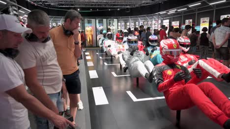 Visitors-look-at-mannequins-dressed-in-racing-suits-highlighting-the-evolution-of-the-F1-sport-and-safety-through-time-during-the-world's-first-official-Formula-1-exhibition