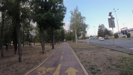 Hyperlapse-shot-shot-from-bike-on-a-two-way-bike-lane-in-the-city-of-Burgas,-parallel-to-a-highway-with-heavy-traffic