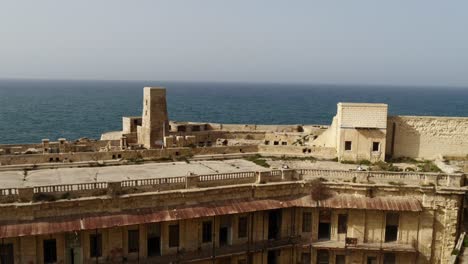 Altes-Ruinöses-Gebäude-Im-Nationalen-Kriegsmuseum---Fort-Saint-Elmo,-Valletta,-Mit-Dem-Mittelmeer-Im-Hintergrund