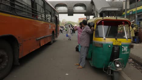 Tuk-Tuk-Driver-waiting-for-customers-on-busy-road,-Delhi-India