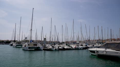 Yacht-marina-with-dozens-of-boats-tied-at-port,-Dolly-in-shot-from-the-water