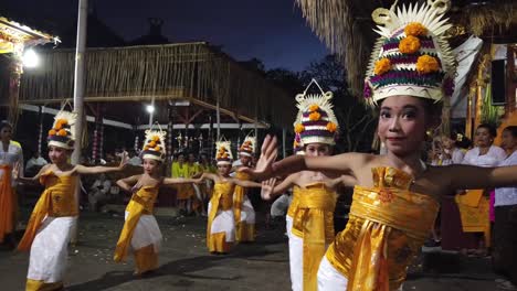 Girls-perform-Rejang-Dewa-Dance-part-of-Balinese-Hinduism-Temple-Ceremony-wearing-Colorful-Outfits-with-Fruits,-Flowers-and-Crowns