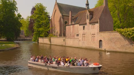 Boats-Tourist-through-canals-in-Bruges-quaint,-Belgium_4K