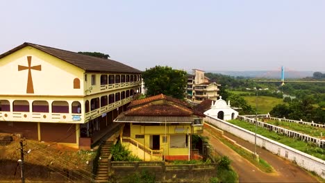 A-drone-shot-flying-over-the-streets-of-Aldona-in-Goa,-India