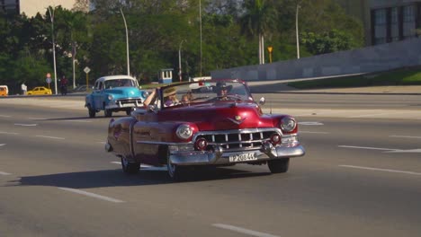 Handheld-tracking-shot-of-a-vintage-car-in-Havana,-Cuba