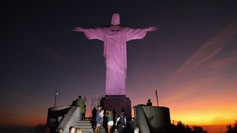 Tourist-visiting-famous-Christ-The-Redeemer-Statue-in-Rio-de-Janeiro-during-golden-sunset-time,-Brazil---Static-wide-shot