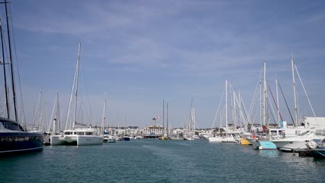 Entering-the-yacht-marina-with-town-building-far-away,-Dolly-in-shot-from-the-water