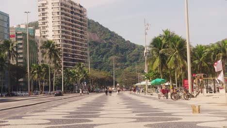 Statische-Aufnahme-Der-Straße-In-Copacabana-Mit-Spaziergängern-Auf-Der-Promenade-An-Sonnigen-Tagen---Rio-De-Janeiro,-Brasilien