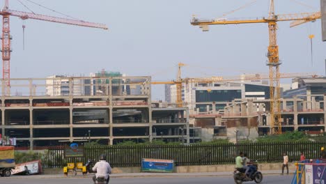 Large-construction-site-of-a-government-owned-building-with-cranes-and-workers,-Hyderabad