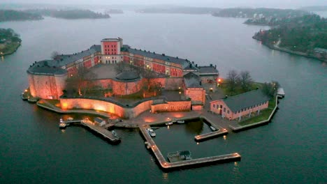 Rotating-panning-aerial-footage-of-Vaxholm-Fortress,-located-right-beside-the-city-of-Vaxholm-in-Sweden