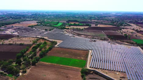 Luftdrohnenkamera-Bewegt-Sich-über-Einen-Solarpark,-Der-Grüne-Energie-Erzeugt-Und-An-Ein-Nahegelegenes-Kraftwerk-Liefert