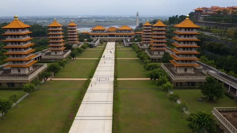 Drone-aerial-forward-flying-view-of-Fo-Guang-Shan-Buddha-Museum-complex-with-wetlands-and-ocean-in-distance