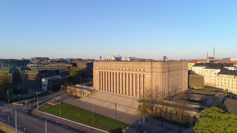 Aerial-tracking,-drone-shot-of-the-Parliament-house-in-Helsinki,-Finland,-during-a-sunny,-summer-sunrise