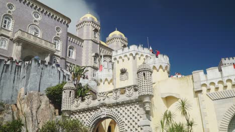 Tilting-Up-Shot,-Scenic-view-Exterior-Design-of-The-Pena-National-Palace,-Blue-Sky-in-the-background-in-Portugal