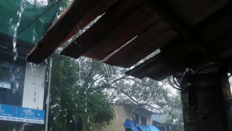 Monsoon-heavy-rain-through-roof-in-shed,-Mumbai,-India,-Static-shot