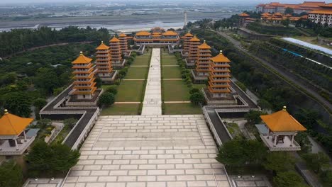 Drone-aerial-forward-flying-view-of-Fo-Guang-Shan-Buddha-Museum-complex-with-wetlands-and-ocean-in-distance