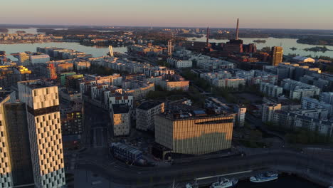 Aerial,-rising,-drone-shot-over-the-Ruoholahti-area,-in-Helsinki,-sunny-spring-sunrise,-in-Helsingfors,-Finland