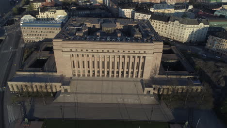 Aerial,-orbit,-drone-shot-around-the-Parliament-of-Finland,-sunny-morning-sunrise,-in-Toolo,-Helsinki