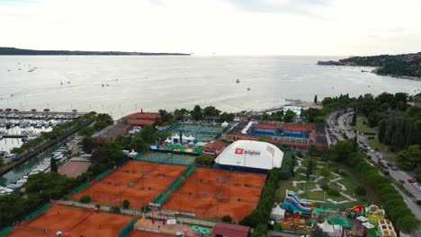 Fast-forward-drone-aerial-flying-over-seaside-coastal-town-of-Portoroz---ATP-Challenger-Slovenia-Open-tennis-grounds