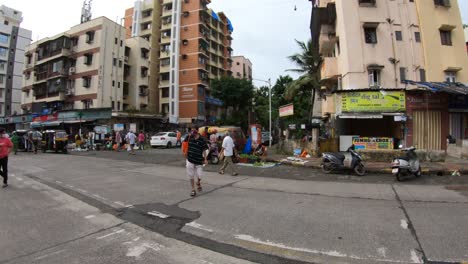 Few-People-Buying-Goods-In-Street-Markets-During-The-Pandemic-In-Mumbai,-India---Wide-Shot-Pan-Left