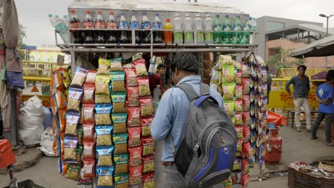 Mann-Kauft-Snacks-Im-Straßenladen,-Delhi,-Indien