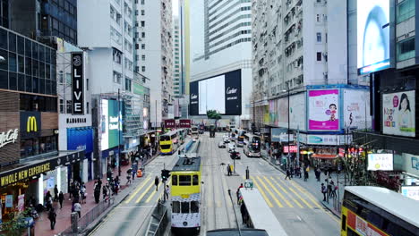 Double-Deck-Tram-Buses-And-Pedestrians-On-The-Busy-Street-In-Hong-Kong-Near-Modern-Commercial-Buildings-With-Digital-Advertisements---Timelapse
