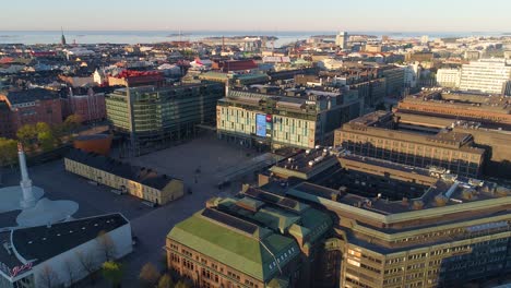 Aerial-view-around-the-Kamppi-shopping-center,-during-sunrise,-in-Helsinki,-Finland---orbit,-drone-shot