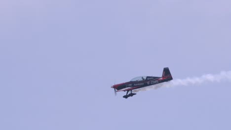 Closeup-slow-motion-shot-of-Extra-300LP-monoplane-performing-aerobatics-with-white-smoke