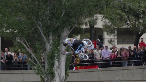 BMX-rider-performs-tail-whip-with-side-flip-in-front-of-spectators