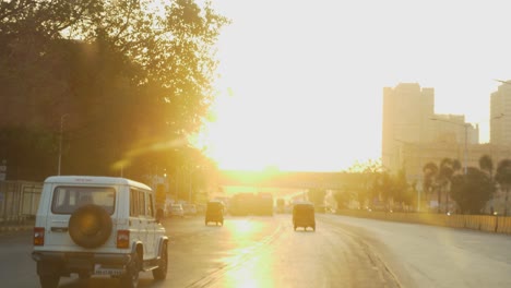 Driving-a-car-on-the-Mumbai-highway-towards-Panvel,-Lonavala,-Pune,-India-at-beautiful-sunrise-with-Mumbai-skyline-buildings-in-view