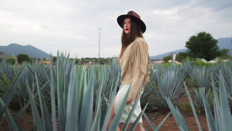 Young-teen-model-elegantly-walking-through-agave-plantation,-in-Jalisco,-Mexico---Tracking-slow-motion-shot
