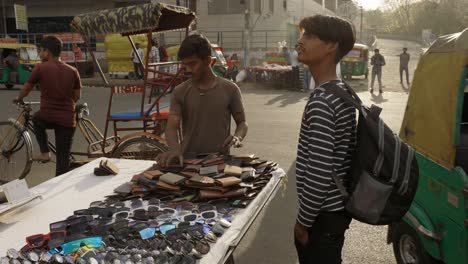 Hombre-Vendiendo-Carteras,-Gafas-De-Sol-Y-Relojes,-Tienda-Callejera,-Delhi,-India