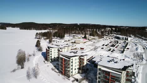 Aerial-view-of-the-Kunnonpaikka-spa,-sunny-winter-day,-in-Kuopio,-Finland---reverse,-drone-shot