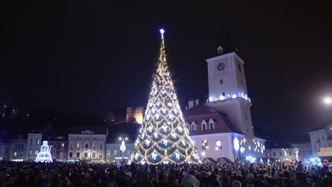 Gente-Esperando-Alrededor-De-Un-árbol-De-Navidad-Para-El-Año-Nuevo,-En-La-Plaza-De-La-Ciudad-De-Brasov,-Rumania