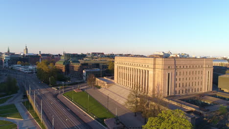 Aerial,-orbit,-drone-shot-of-the-Parliament-house,-in-Toolo,-Helsinki,-Finland,-during-golden-hour,-on-a-sunny,-summer-morning,-in-Finland