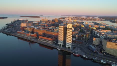 Aerial-view-of-the-Clarion-Hotel-building,-on-a-sunny-morning-sunrise,-in-Jatkasaari,-Helsinki,-Finland---descending,-drone-shot