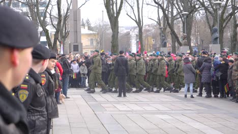 Rack-focus-of-modern,-young-soldiers-watching-military-personnel-on-parade-at-an-event-in-Kaunas,-Lithuania-for-the-Restoration-of-the-State-celebration