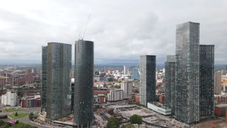 Aerial-view-circling-Deansgate-Manchester-tall-contemporary-glass-window-skyscrapers-and-downtown-cityscape