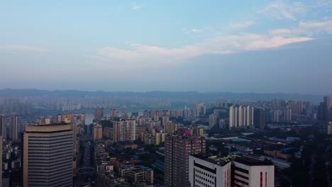 Filmische-Luftaufnahme-Der-Stadtlandschaft-Mit-Wolkenkratzern-Und-Dramatisch-Verschmutztem-Himmel-In-Chongqing,-China