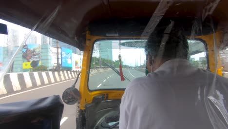 Riding-Auto-Rickshaw-On-The-Empty-Road-With-A-View-Of-High-Rise-Buildings-In-Mumbai,-India---View-Of-A-Passenger-Sitting-Inside---POV-shot---panning-left