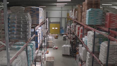 -Forklift-Driving-Around-In-Warehouse-With-Shelves-Full-Of-Wheat