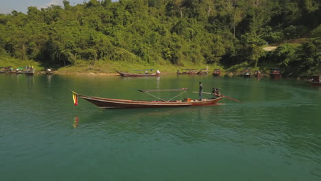 Barco-Tradicional-Tailandés-De-Cola-Larga-Con-Motor-De-Coche-En-Aguas-Verdes-De-Una-Exótica-Laguna-Rural,-Vista-Aérea