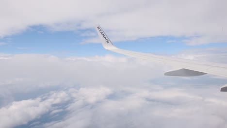 On-an-airplane-soaring-through-the-clouds-on-a-bright-sunny-day---wide-shot