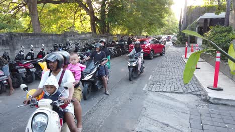 Scooters-Conduciendo-En-El-Estacionamiento-De-La-Entrada-De-La-Playa-De-Sanur,-Bali,-Indonesia,-Gente-Local-De-Indonesia,-Sudeste-Asiático-Durante-El-Día.