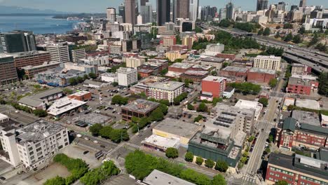Drone-shot-tilting-up-from-Seattle's-Chinatown-to-reveal-the-downtown-skyscrapers-in-the-distance