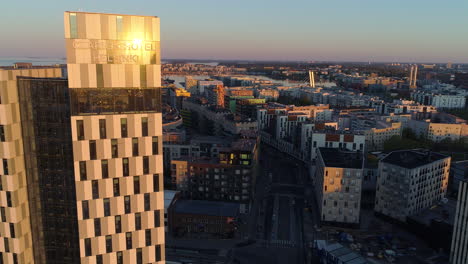 Hotel-Helsinki,-Aerial-tracking,-drone-shot-in-front-of-the-Clarion-Hotels-building,-on-a-sunny-morning-sunrise,-in-Jatkasaari,-Helsinki,-Finland
